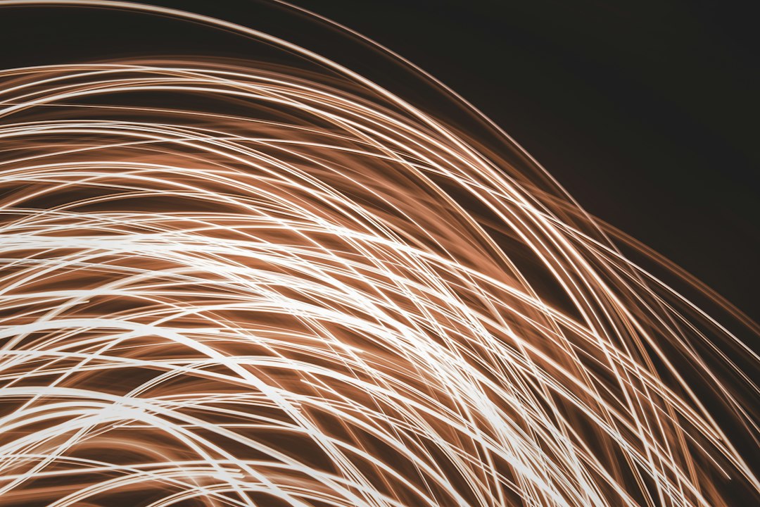 A pair of hands carefully untangling a complex knot of brightly glowing fiber optic wires against a clean background, symbolizing the act of finding truth and clarity amidst confusing information.